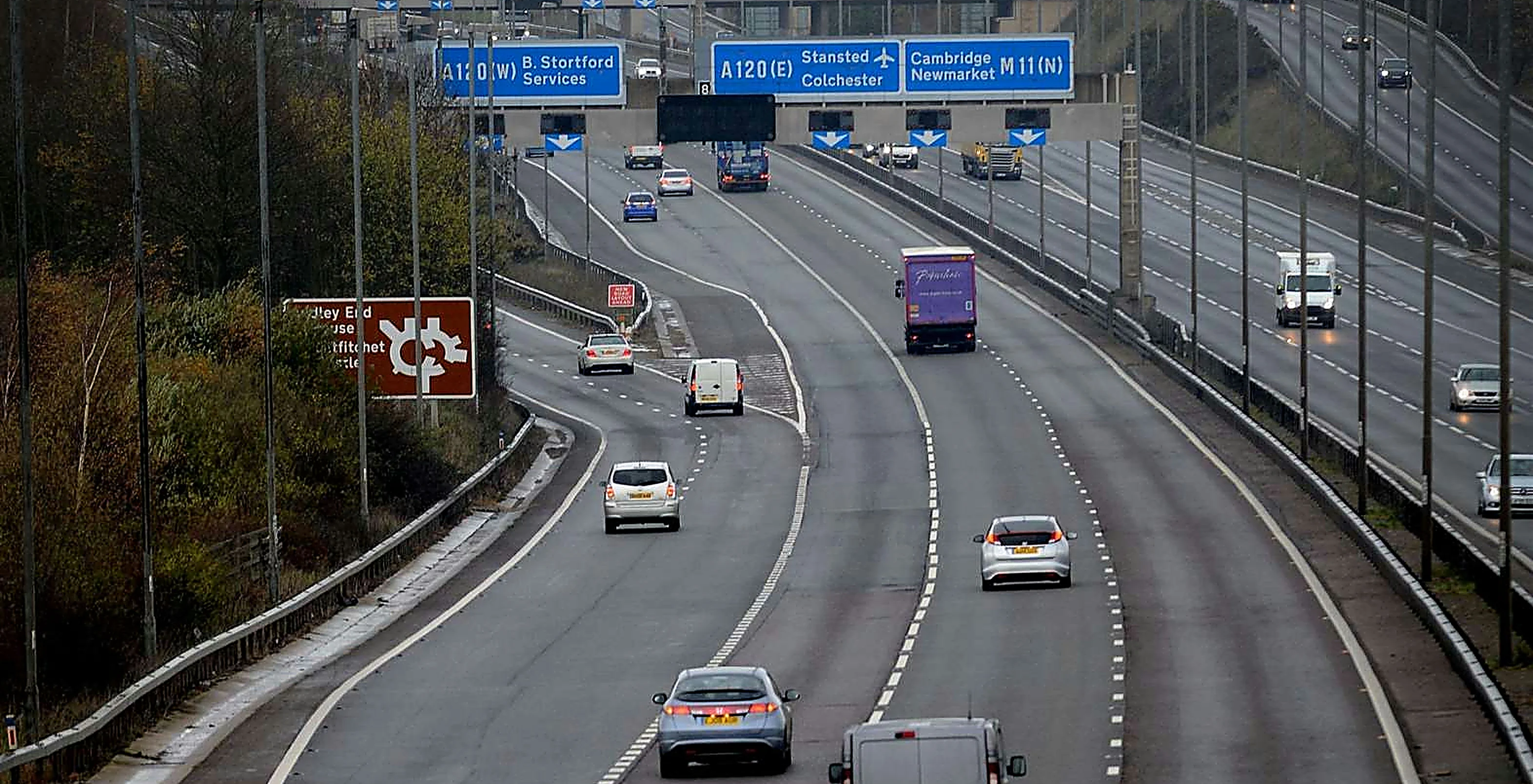 Overhead motorway signs above the M11 at Junction 8, showing directions for the A120, Stansted Airport, Cambridge and Newmarket